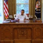 President Barack Obama at his desk, thinking. White House photo.