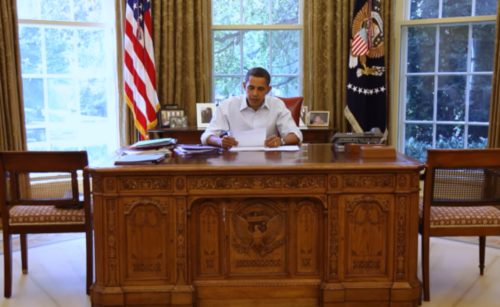 President Barack Obama at his desk, thinking. White House photo.