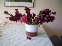 maroon snapdragons arranged awkwardly in a white glass vase. photo by bf newhall