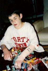 Ten-year-old boy with broken arm sorting Halloween candy. Photo by BF Newhall