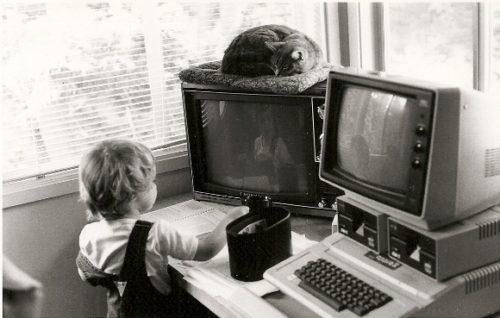 1986 home office with computer monitors, toddler and sleeping cat. Photo by BF Newhall.