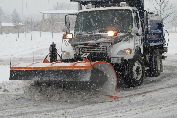 Snowplow clearing snow in a snowstorm at Eden Prairie, MN, Community Center. Photo 2013 by BF Newhall