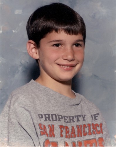 Eight-year-old boy with fat lip and Giants T-shirt, smiling. BF Newhall photo.