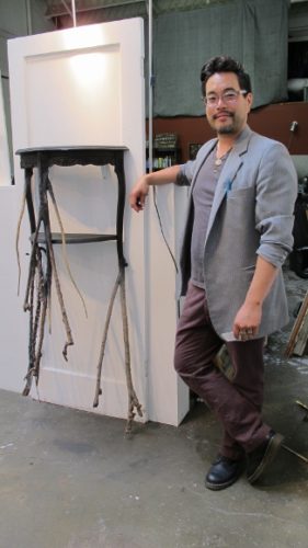 Curtis H. Arima, a Berkeley sculptor, with a sculpture made of an old side table and thorny sticks. Photo by  BF Newhall