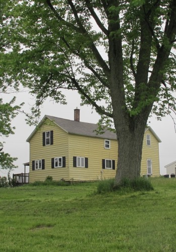 A two-story yellow frame farmhouse outside Scottville MI that is more than 100 years old. It once belonged to the David Falconer family. Photo by BF Newhall