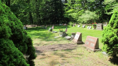 A row of grave markers and a newly covered grave at the Brookside Cemetery, Scottville, MI. Photo by BF Newhall