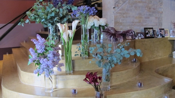 Several vases of flowers including callas, lilacs, and eucalyptus leaves decorate a stairway at the Five Event Center. Photo by BF Newhall