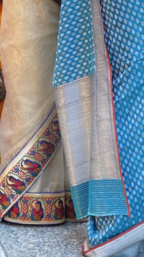 An ivory silk sari bordered with red and blue images with a blue dotted sari at an Indian wedding. Photo by BF Newhall