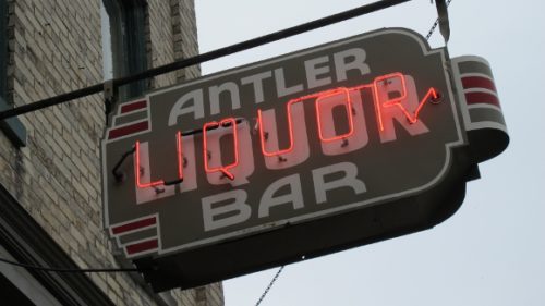 neon sign outside the antler bar in pentwater michigan with the word liquor in red. Photo by BF Newhall