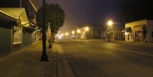 Street scene of Pentwater, Michigan, after dark, with North Hancock lit by street lights. Photo by BF Newhalls. pho