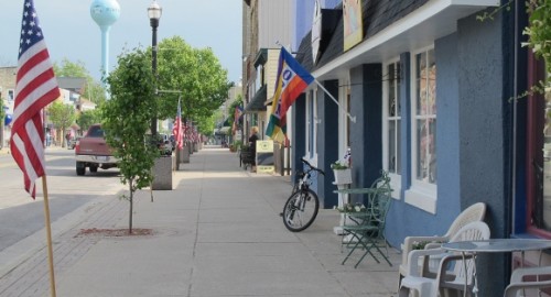 North Hancock Street, Pentwater, Michigan, with shops, flags and trees. Photo by BF Newhall