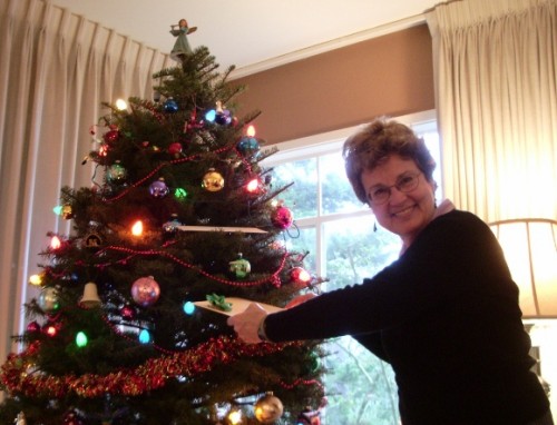a happy woman finds a gift for herself in the christmas tree. photo by jon newhall