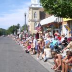 fourth of july in pentwater michigan. people sit on curb awaiting the parade. photo by bf newhall