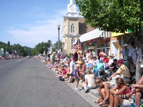 Downtown Pentwater Michigan village on 4th of July with people sitting on curb waiting for the parade. Photo by BF Newhall