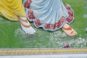 An image of the feet of the deity Rahda Krishna at the Radha Madhav Dham Hindu temple complex, austin, texas.