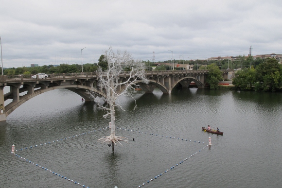 The temporary art installation THIST's Ghost Tree hovers above Lady Bird Lake, as seen from Austin, TX, Pfluger Pedestrian Bridge. Photo by BF Newhall