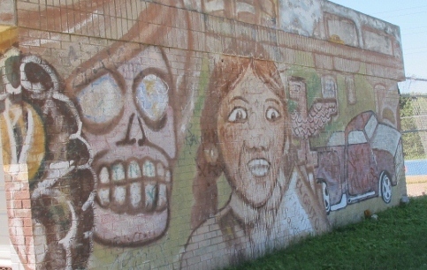 A light-coiored graffiti mural on a building in Austin TX with skull and a woman's face. Photo by BF Newhall
