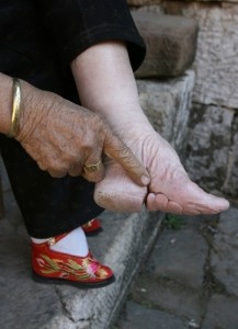 a chinese woman shows her bound foot.