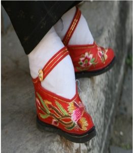 red embroidered shoe with strap on the bound foot of a Han Chinese woman. 