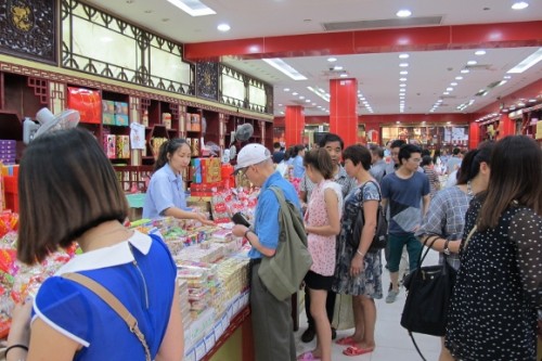a single westerner in a crowd of chinese shopper in a well-stocked candy story at Yu Gardens and Bazaaar in Shanghai. Photo by BF Newhal