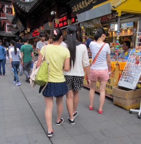 china's young fashionistas. three girls in shorts and shorts skirts on street in shanghai market. Photo by BF Newhall