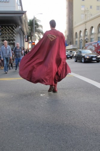 Actor Christopher Dennis dressed as Superman crosses Holllywood street cape billowing. Photo by BF Newhall
