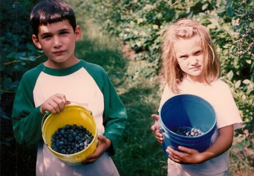 Two children show off the buckets of blueberries they've picked in Michigan. Photo by BF Newhall