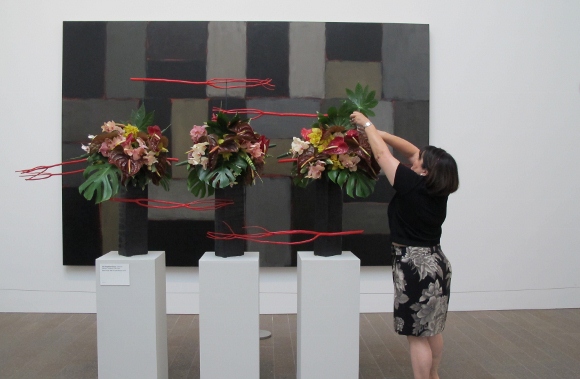 Catherine Matsuyo Tompkison puts last touches on floral design reflecting Sean Scully's "Wall of Light Horizon, 2005." Photo by BF Newhall