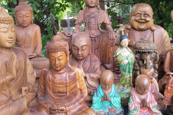 An array of wood carvings of gods and goddesses including buddha and ganesh on display table at Himalayan Fair Berkeley, May 2014. Photo by BF Newhall