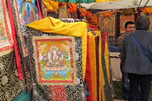 Kathmandu artist in his stall at Himalayan Fair Berkeley 2014 with dozens of thangkas from Nepal. Photo by BF Newhall