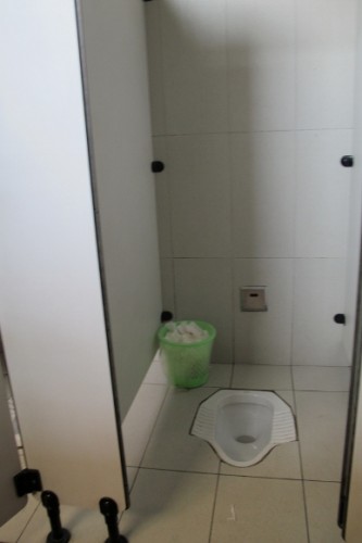 The poop on China -- a toilet stall in a lavatory in Xian, China, has a white porcelain toilet that is flush with the floor and a basket for used toilet paper. Photo by BF Newhall
