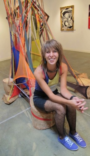Hannah Woebkenberg sits in front of a large sculpture made with dyed pantyhose. Photo by BF Newhall