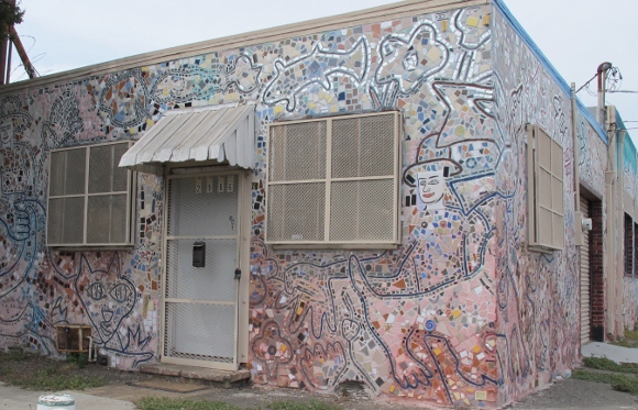 A building in Jingletown district of Oakland, CA, is covered with pastel tesserae mosaics of animals and people. Photo by BF Newhall