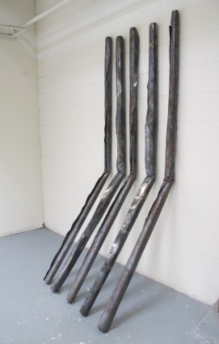 A Christopher Kanyusik sculpture of five 4x8-foot sheets of steel rolled and bent and leaning against a wall. Photo by Bf Newhall