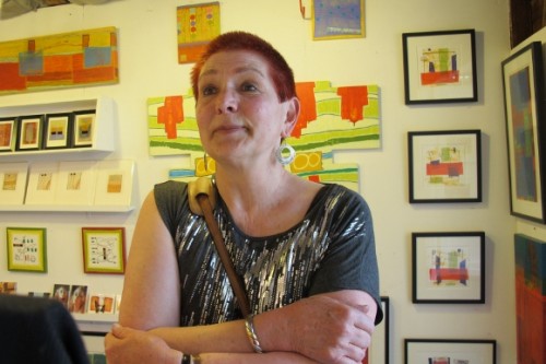 Berkeley painter Judy Seidel in a gallery of her colorful abstract paintings. Photo by BF Newhall