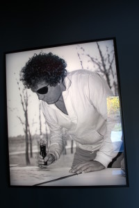 A black and white photo of glassblower Dale Chihuly at work hangs in the the Chihuly Garden and Glass museum in Seattle.