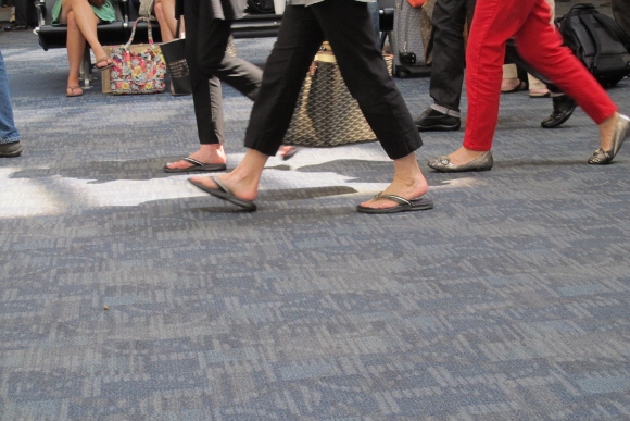 We see the feet of passengers rush to and from Delta Air flights at SFO. 