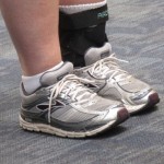 A girl at SFO wears cross trainers and a brace on her ankle. PHoto by Barbara Newhall