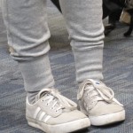 A pigeon-toed girl at SFO wears gray tights and white sneakers, her toes pointed in. Photo by Barbara Newhall