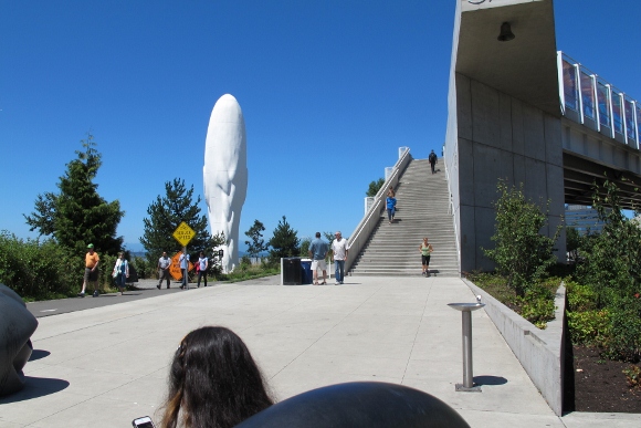 "Seattle Cloud Cover," by Teresita Fernandez, 2006, a pedestrian bridge with photographic material between layers of glass. To the left "Echo" "Echo" by James Plensa. 46 feet tall. Resin, steel, marble dust. 13,118 pounds. May, .Photo by Barbara Newhall