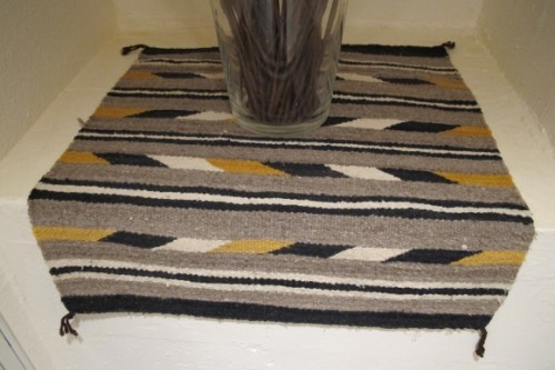 A small, coarsely woven Navajo rug of grey, black and gold. Photo by Barbara Newhall