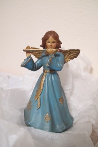 A plastic angle with a blue gown plays a golden flute. Photo by Barbara Newhall
