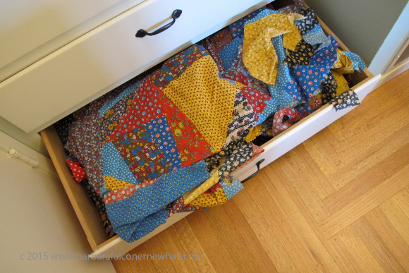 An unfinished quilt and stray piece of calico overflow from a storage drawer. Photo by Barbara Newhall