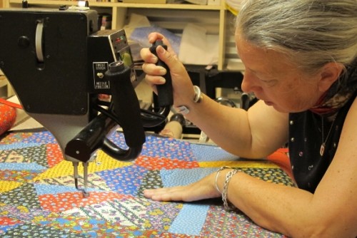 Sue Mary Fox quilting stitches a crazy quilt -- quilt top, batting and backing -- with her long arm sewing machine in her Berkeley, CA, studio. Photo by Barbara Newhall