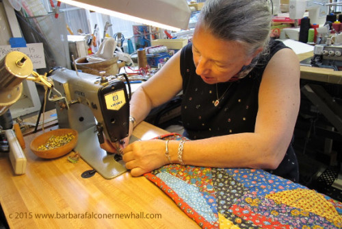 Sue Mary Fox hems a colorful calico crazy quilt on a sewing machine in her Berkeley, CA, studio. Photo by Barbara Newhall