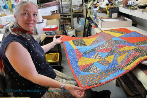 Sue Mary Fox shows off the calico quilt that she stitched together and quilted for a client. It is Barbara Falconer Newhall's crazy quilt. Photo by Barbara Newhall