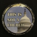 A button displaying the dome of a captol has the words "This is not a church.: photo by Barbara Newhall