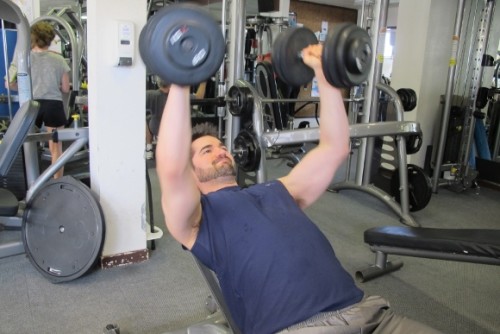 weight lifting. My son Peter Newhall, a man in his 30s, lifts dumbbells at the gym. Photo by Barbara Newhall