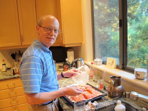 politics of housework. Jon cheerfully prepares salmon for a birthday dinner for his wife. Photo by Barbara Newhall