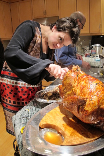 Christina Newhall takes stuffing from 2013 Thanksgiving turkey. Dad Jon helps. Photo by Barbara Newhall